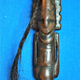 A carved human-like figure on the wooden snuffing tube.